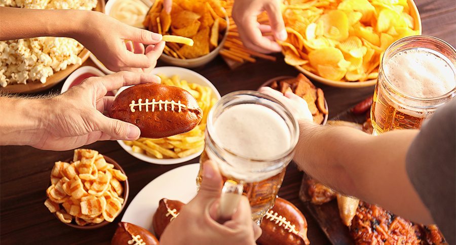 Close up view of hands taking snacks from plates during party